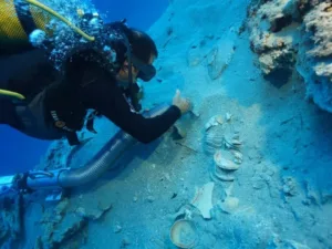Un arqueólogo submarino retira con delicadeza la arena que cubre un conjunto de cerámicas apiladas halladas en un pecio frente a la costa turca
