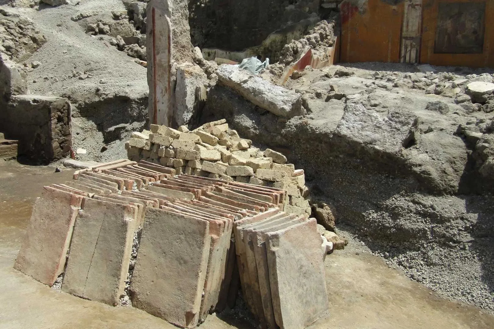 atrio-hallazgo-pompeya | Planeta 16 En el atrio 2 de la Regio IX, recientemente excavada en el Parque Arqueológico de Pompeya, aparecieron hileras ordenadas de tejas cerámicas junto a un apilamiento de bloques de toba amarilla, claramente dispuestos para ser reutilizados en las labores de reconstrucción que estaban en marcha